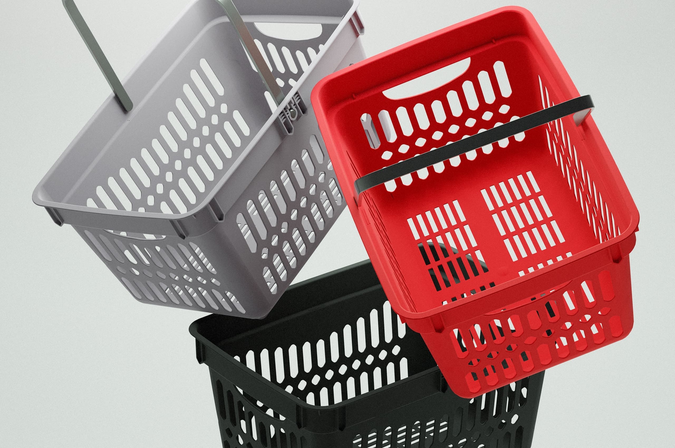 tre kundkorgar i plast, färgade i grå, röd och svart