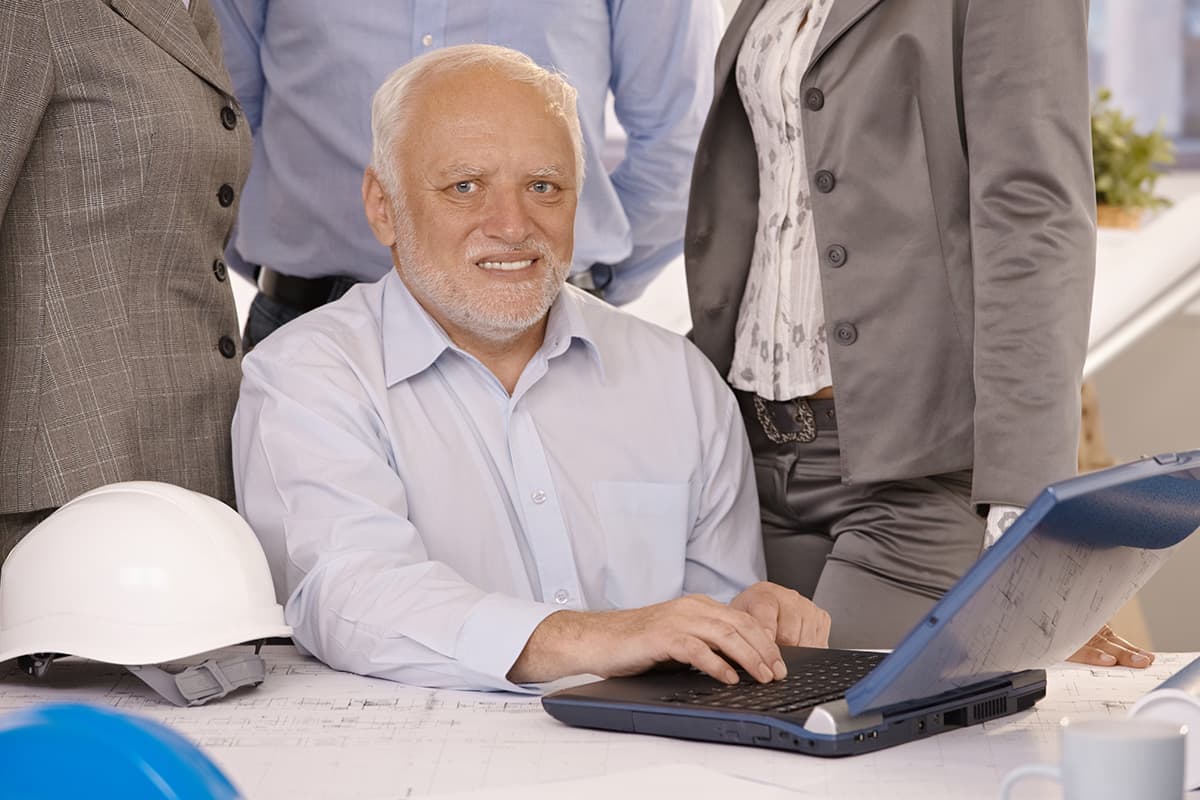 En stockbild med András Arató, också känd som "Hide the pain Harold" sittandes framför en laptop