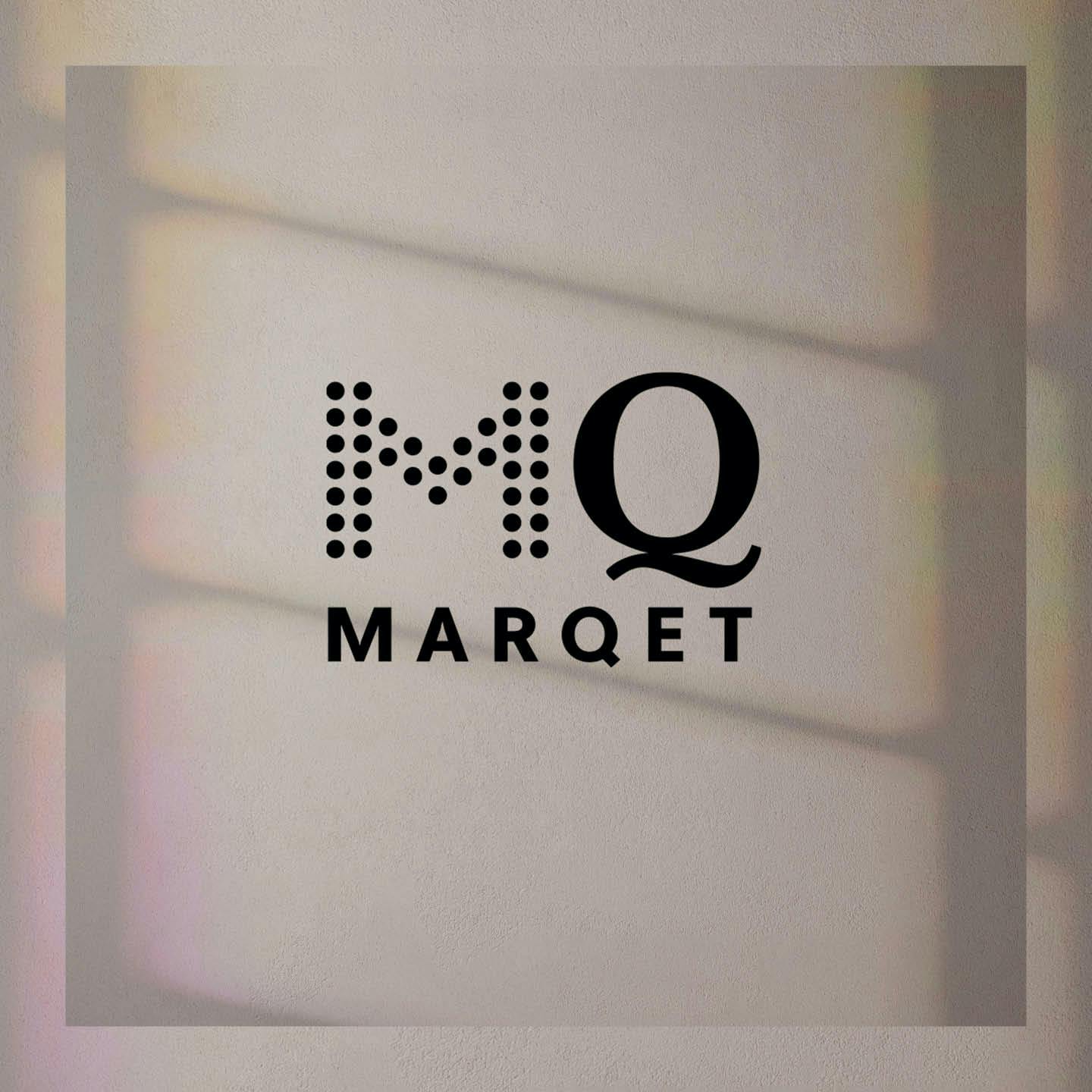 Logotypen för MQ Marqet på en skuggad vägg