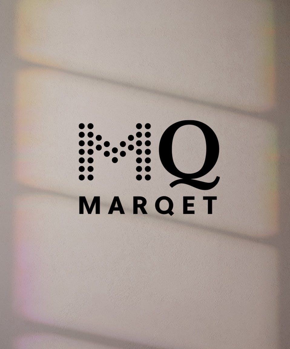 Logotypen för MQ Marqet på en skuggad vägg